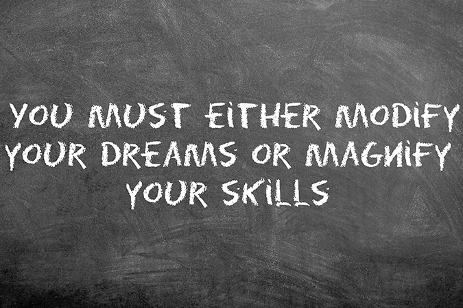 chalkboard with quote that you must either modify your dreams or magnify your skills